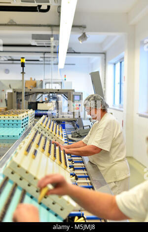 Herstellung von Pralinen in einer Fabrik für die Lebensmittelindustrie - Frauen arbeiten an der Montagelinie Stockfoto
