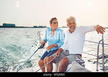 Reifes Paar sitzen zusammen auf dem Deck Ihres Bootes genießen den Tag Segeln auf dem Ozean Stockfoto