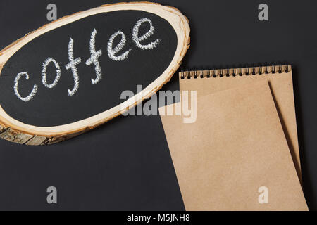 Typenschild aus einer Birke Board mit dem Text 'Kaffee' auf einem schwarzen Brett. Bild mit Platz für Ihren Text, Rezeptur oder Menü. Ansicht von oben. Stockfoto