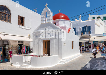 MYKONOS, Griechenland - 23. Mai 2017: Ein Blick auf die typische griechische Kirche Gebäude auf Platz mit Geschäften in der Stadt Mykonos. Die Kykladen, Griechenland Stockfoto