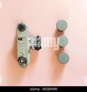 Alten retro Kamera mit drei Kontrollkästchen für Film auf rosa Hintergrund. Konzept. Stockfoto