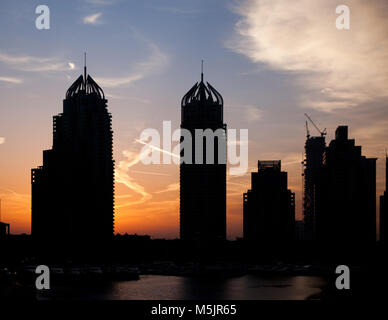 DUBAI, VAE - Februar 2018: die Silhouetten von modernen Wolkenkratzern in Sunrise Leuchten in Dubai Marina in Dubai, VAE. Stockfoto