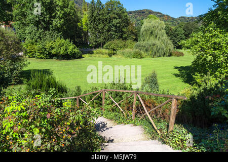 Querformat der Naturpark mit Pfad, Weg, Wiese, Grün große Bäume mit kleinen Hügeln und Wald auf der strahlend blaue Himmel Hintergrund. Stockfoto