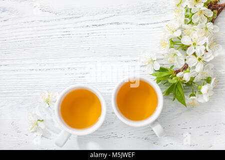 Zwei Tassen Tee und Niederlassung von blossom Cherry auf weissem Holztisch. Stockfoto