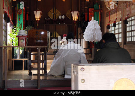 Ein Shinto Priester führt ein Ritual an Onechi Schrein. In Iizuka, Japan, Februar 2018 berücksichtigt. Stockfoto