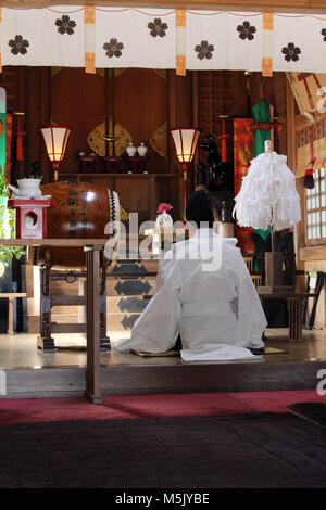 Ein Shinto Priester führt ein Ritual an Onechi Schrein. In Iizuka, Japan, Februar 2018 berücksichtigt. Stockfoto