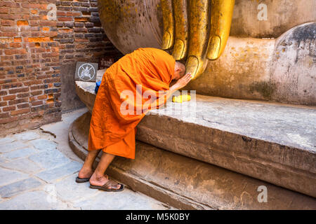 SUKHOTHAI, Thailand, 23. Februar 2017 - Mönch betet unter die Statue des Großen Buddha von Wat Si Chum Sukhothai, Thailand Stockfoto