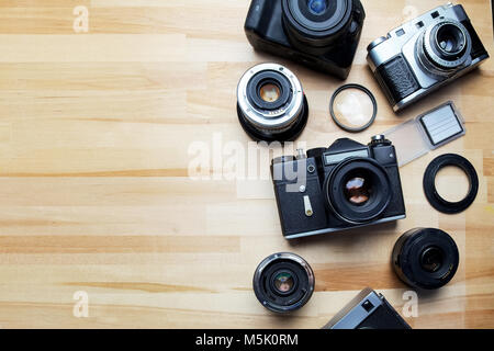 Mischen von alten Kameras auf hölzernen Schreibtisch-Hintergrund. Stockfoto