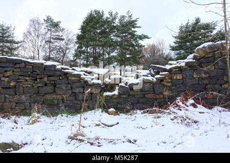 Zusammengebrochen Deich Mauer im Schnee bedeckt die Landschaft Stockfoto