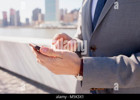 Geschäftsmann mit seinem Handy auf einem Dach in der Stadt Stockfoto