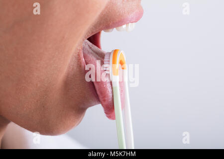 Foto der jungen Frau, die Reinigung der Zunge mit Reiniger Stockfoto