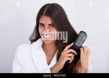 Porträt einer Frau im Bademantel Kämmen zu Hause Stockfoto