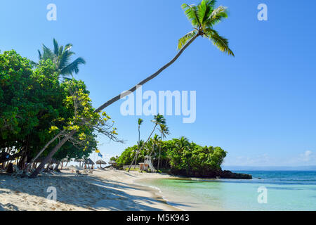 Schöner Strand mit weissem Sand, türkisfarbenes Wasser, Palmen und ihre Schatten voraus. Stockfoto