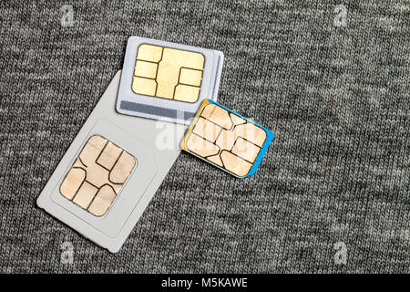 Satz von Mini, Mikro und Nano-SIM-Karte. Auf grauen Tuch Textur Hintergrund isoliert Stockfoto