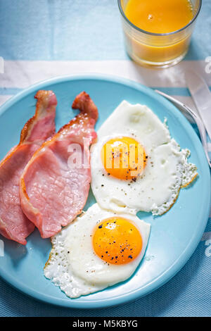 Spiegeleier mit Speck und Orangensaft Stockfoto