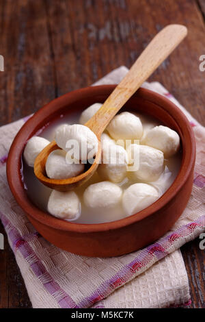 Kleine mozzarella Kugeln in Salzlake auf einem rustikalen Tisch Stockfoto