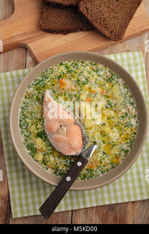 Finnische Fischsuppe kalakeitto mit Lachs und Creme auf einem rustikalen Tisch Stockfoto