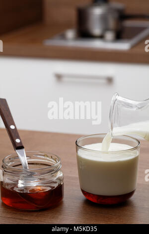 Honig und Milch auf einem Küchentisch Stockfoto