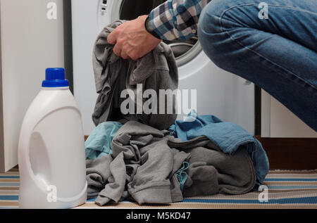 Mann, schmutzige Wäsche in die Waschmaschine geöffnet Stockfoto