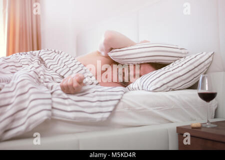 Betrunken reifer Mann schlafend in seinem Bett Stockfoto