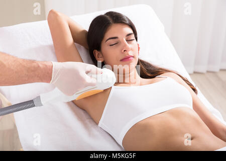 Junge Frau in den Achselhöhlen und der Laser Haarentfernung Behandlung im Beauty Spa Klinik Stockfoto