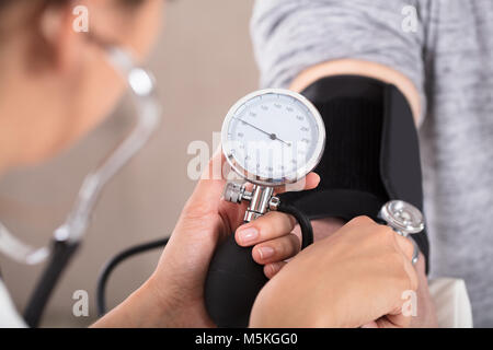 Arzt Kardiologe Blutdruck messen der männlichen Patienten in der Klinik Stockfoto