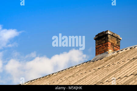 Dach des Hauses mit Schiefer gedeckt und ein Kamin im Frühjahr Stockfoto