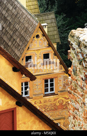 Das geneigte Dach des Torhauses Gebäude von Grodno schloss mit wertvollen Sgraffiti an den Wänden. Zagorze Slaskie, Niederschlesien, Polen. Stockfoto