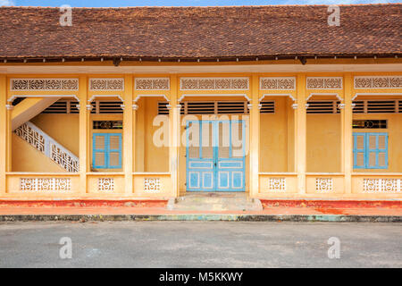 Blaue Türen auf gelbem Hintergrund außerhalb der Cao Dai Tempel Heiliger Stuhl, Tay Ninh Provinz, Vietnam. Stockfoto