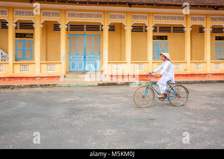 Cao Dai weiblichen Anhänger fahren mit dem Fahrrad auf dem Gelände des Heiligen Stuhls Cao Dai Tempel, đà Ninh, Vietnam Stockfoto