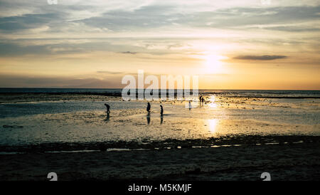 Die Menschen sind zu Fuß am Strand gesehen, als die Flut ist auf Gili T Insel während einer Golden Sunset in Bali. Stockfoto