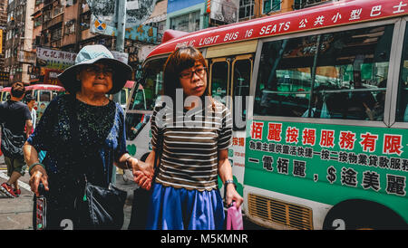 Eine Tochter ihre Mutter hilft, überqueren Sie die Straße in Hongkong Kond Stockfoto