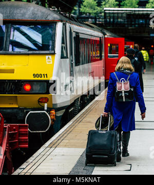 Eine Frau Spaziergänge entlang der Plattform in der Liverpool Street Station mit dem Zug von London aus zu fangen Stockfoto