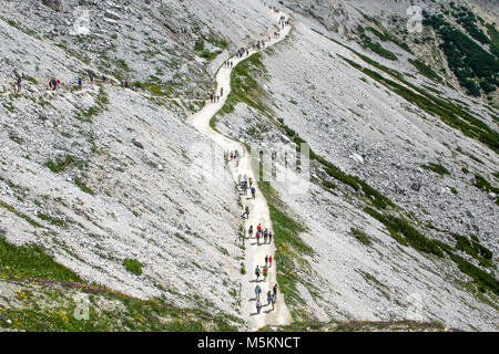 Eine Gruppe von Menschen mit Rucksäcken zu Fuß entlang des Weges. Stockfoto