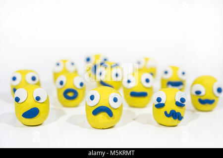 Abstrakte Foto mit gelben Smileys aus dem Spiel Ton gemacht. Menschen Masse Emotionen. Auf weissem Hintergrund. Stockfoto