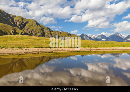 Spiegelungen der Berge und Wolken in einem Bergsee, im Kaukasus, in Georgien. Stockfoto