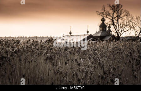 Sunrise gegen ortodox Kloster sourenden durch gefrorene Felder, Schilf und Schnee draussen im Osten von Polen in der Nähe von Bielarus Grenzen Stockfoto