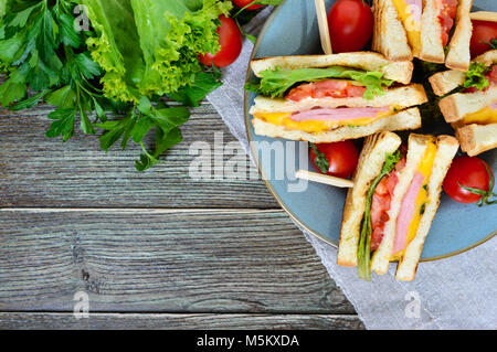 Club-Sandwiches mit knusprigem Toast, Wurst, Käse, Tomaten, Grüns. Traditionelle amerikanische Snack. Die Ansicht von oben Stockfoto