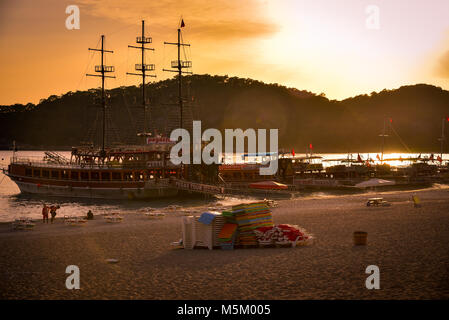 Oludeniz, Türkei - Mai 07, 2017: Boote zurück von einem täglichen Touren und einige Touristen noch bleiben am Strand. Editorial Foto. Stockfoto