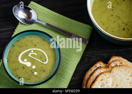 Gesunde grüne Suppe auf einem dunklen Holztisch Stockfoto