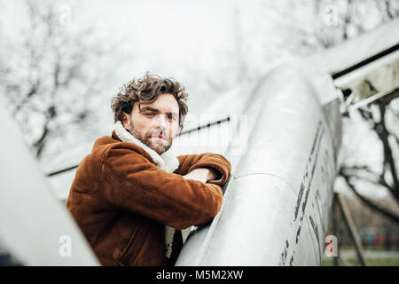 Maskulin und souverän Mann, in einem Pilot Jacke, stehen neben einem alten Flugzeug Stockfoto