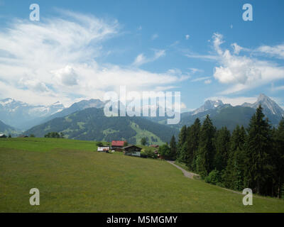 Schweizer Landschaft mit grünen Wiesen, schneebedeckte Berge und kleine Häuser Stockfoto