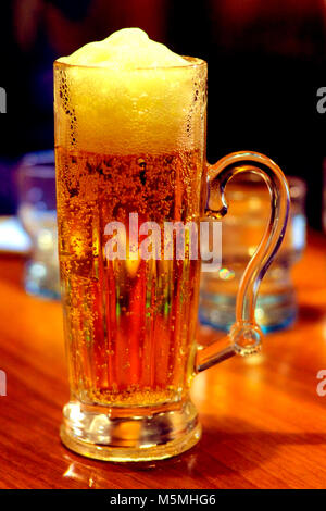 Bier Glas in der Hand Stockfoto