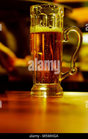 Bier Glas in der Hand Stockfoto