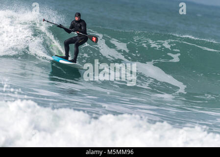 Ein Paddel boarder einer Welle an Fistral in Newquay, Cornwall. Stockfoto