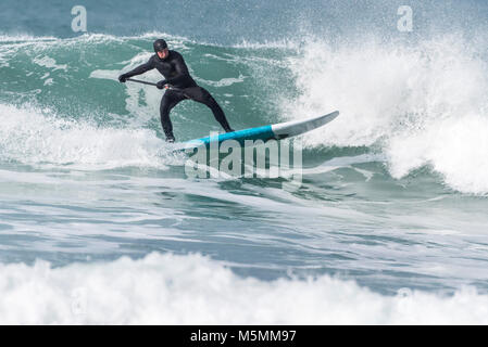 Ein Paddel boarder einer Welle an Fistral in Newquay, Cornwall. Stockfoto