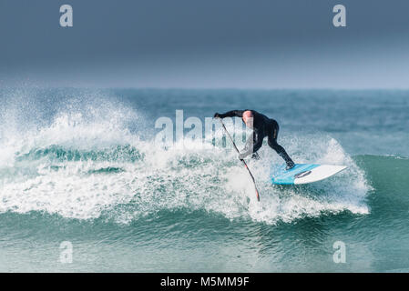 Ein Paddel boarder einer Welle an Fistral in Newquay, Cornwall. Stockfoto