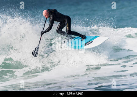 Ein Paddel boarder einer Welle an Fistral in Newquay, Cornwall. Stockfoto