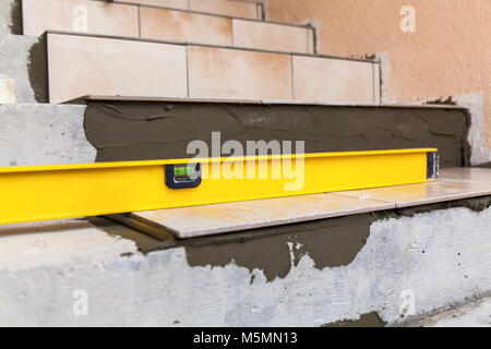 Keramische Fliesen und Werkzeuge für Fliesenleger. Bodenfliesen Installation. Home Verbesserung, Renovierung Fliesen Kleber, Ebene. Stockfoto