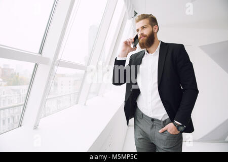 Unternehmer im Gespräch mit dem Telefon im Büro Stockfoto
